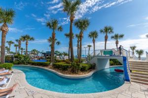 a pool with a slide at a resort with palm trees at Newly Renovated Paradise 8th Floor 2BR with Private Oceanfront Balcony at Ocean Walk Resort in Daytona Beach