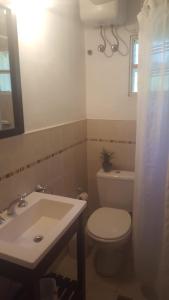 a bathroom with a white toilet and a sink at Casas del Abra Vieja in Tigre