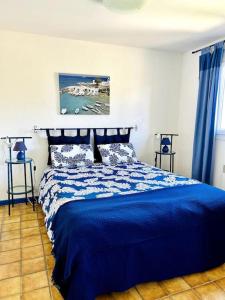a bedroom with a bed with a blue comforter at Maison Parc du Verdon - Clim & Terrasse ombragée in Les Salles-sur-Verdon +39 photos