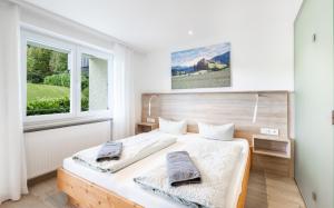 a bedroom with a bed and two windows at Bergwald Panorama Suiten in Scheidegg +49 photos