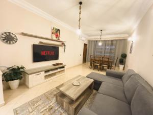 ein Wohnzimmer mit Couch und Fernseher in der Unterkunft Top localisation, neuf, Piscine et une vue balcon in Marrakesch