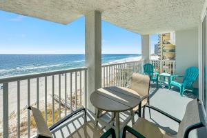 a balcony with chairs and a table and the ocean at Romar Tower Unit 8C in Orange Beach