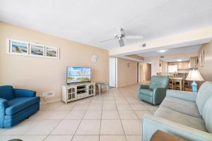 a living room with blue chairs and a tv at Romar Tower Unit 8C in Orange Beach +37 photos