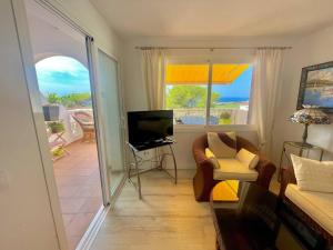 een woonkamer met een bank en een televisie bij Suite with views of son bou beach in Son Bou