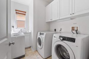 lavadero blanco con lavadora y lavadora en Large home- sleeps 16, en Fallbrook