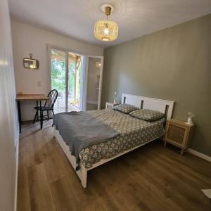 a bedroom with a bed and a desk and a window at La Litoise in Lit-et-Mixe
