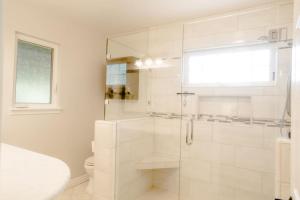a white bathroom with a shower with a glass door at Grass Valley Home with Hot Tub in Grass Valley +39 photos