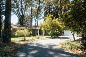 a house in the woods with a driveway at Grass Valley Home with Hot Tub in Grass Valley