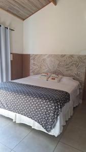a bedroom with a bed with a blue and white comforter at Pousada e Cervejaria Amor in Malte in Lavrinhas