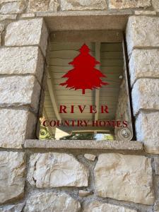 a sign that says river county homes in a window at River Country Homes in Kalavrita