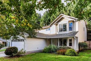 a white house with a yard at Cozy Family Home with Hot Tub and Workspace Near Portland in Vancouver