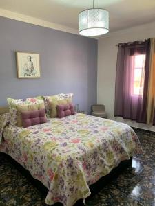 a bedroom with a large bed with a colorful bedspread at Vacacional Tegueste 1ºA in Vecindario