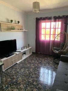 a living room with a flat screen tv and a window at Vacacional Tegueste 1ºA in Vecindario