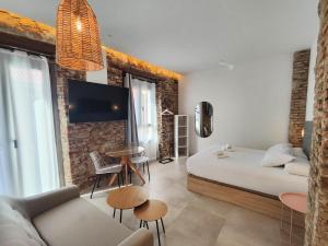 a room with a bed and a couch and a tv at La estación in Málaga