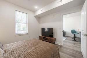 ein Schlafzimmer mit einem Bett und einem Flachbildfernseher in der Unterkunft Libby Hill Apt - TH09 - Tourist Homes of Richmond in Richmond