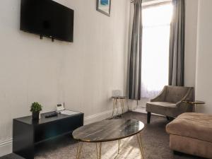 a living room with a tv and a couch and a table at 21 Eaves Street in Blackpool