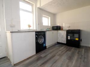 a kitchen with a washer and dryer in a room at 21 Eaves Street in Blackpool +15 photos