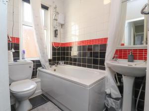 a bathroom with a toilet and a tub and a sink at 21 Eaves Street in Blackpool