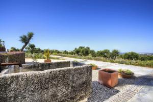 a stone wall with potted plants on a sidewalk at Retiros Los Agustinos in Arcos de la Frontera