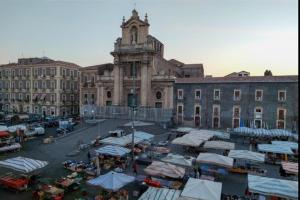 a market in front of a building with a clock tower at casa catania termini home 3 in Catania