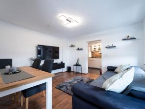 a living room with a blue couch and a table at Ferienwohnung Sunny in Schmallenberg