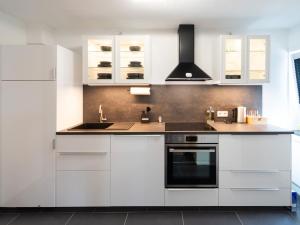 a white kitchen with white cabinets and a sink at Ferienwohnung Sunny in Schmallenberg