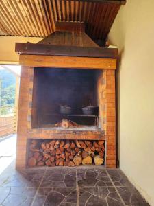 a brick fireplace with a pile of fire wood at KAZISAAk in La Possession