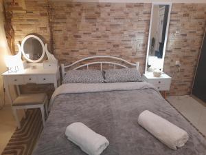 a bedroom with a bed with two pillows and a mirror at Minimal Studio. in Kavala