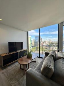 a living room with a couch and a large window at Amplio Departamento en Sao Paulo Vertical in Guadalajara
