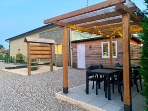 a patio with a black table and chairs under a pergola at Borgo Terra village in Fagagna