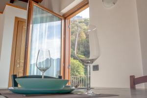 two wine glasses sitting on a table with a window at Larius Apartment - Como Lake View - Free Parking in Mandello del Lario +23 photos