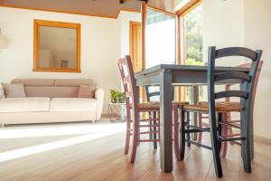 a table and chairs in a living room with a couch at Larius Apartment - Como Lake View - Free Parking in Mandello del Lario