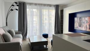 a living room with a couch and a table at La Vie en Rose & Bleue - Louez L'Esprit Libre ! in Bussy-Saint-Georges