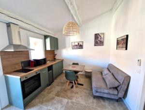 a kitchen with a counter and a chair and a table at Sadi Carnot in Arles