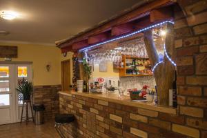 a bar in a restaurant with a brick wall at Verona Panzió in Döbrököz