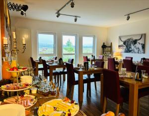 ein Restaurant mit Tischen und Stühlen, auf denen Essen steht in der Unterkunft Hotel Rappenhof in Breuna