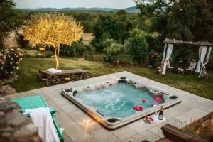 a hot tub in the backyard of a house at Opulent Villa with Sauna in the Heart of Karst in Dutovlje