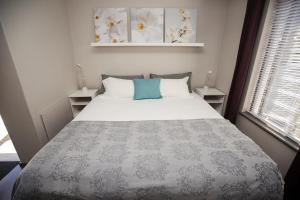 a bedroom with a large bed with a blue pillow at Chapman's Peak Bed and Breakfast in Hout Bay