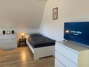 a bedroom with a bed and a flat screen tv at Monteurzimmer Deluxe in Ibbenbüren