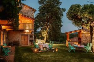 a house with a table and chairs in the yard at Opulent Villa with Sauna in the Heart of Karst in Dutovlje