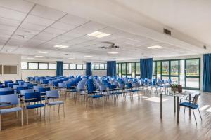 Zimmer mit blauen Stühlen, Tischen und Fenstern in der Unterkunft VOI Daniela Essentia in Conca Specchiulla + 44 Fotos