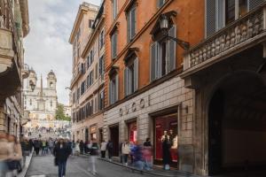 a group of people walking down a street with buildings at V Collection Condotti in Rome