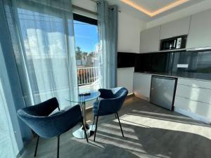 a living room with two chairs and a glass table at SCIROCCO SUITES Madeira - Ocean View in Água de Pena