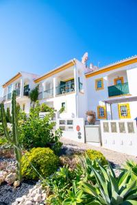 Casa Tara - Lovely Carvoeiro apartment في برايا دو كارفويرو: منزل أبيض كبير مع سور