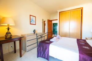 Casa Tara - Lovely Carvoeiro apartment في برايا دو كارفويرو: غرفة نوم بسرير ومكتب ومصباح