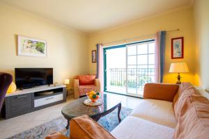 Casa Tara - Lovely Carvoeiro apartment في برايا دو كارفويرو: غرفة معيشة مع أريكة وتلفزيون