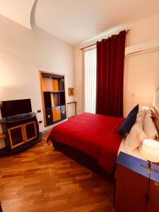 a bedroom with a red bed and a flat screen tv at LaNova21 in Naples