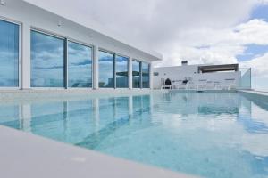 ein Swimmingpool mit blauem Wasser in einem Gebäude in der Unterkunft Villa Noelia Ocean View in Prazeres