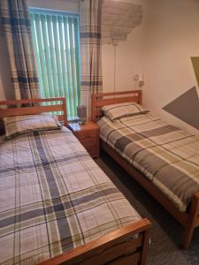 a bedroom with two beds and a window at clifftop villa 47 in Corton