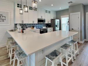 cocina con encimera blanca grande y taburetes en Copano Coastal Gem, en Rockport